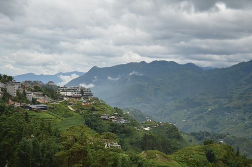Free A picturesque mountain landscape with a village and cloudy sky, showcasing natural beauty. Stock Photo