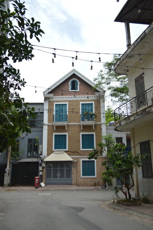 Free Street view of charming architecture with fairy lights and greenery, capturing urban lifestyle aesthetics. Stock Photo