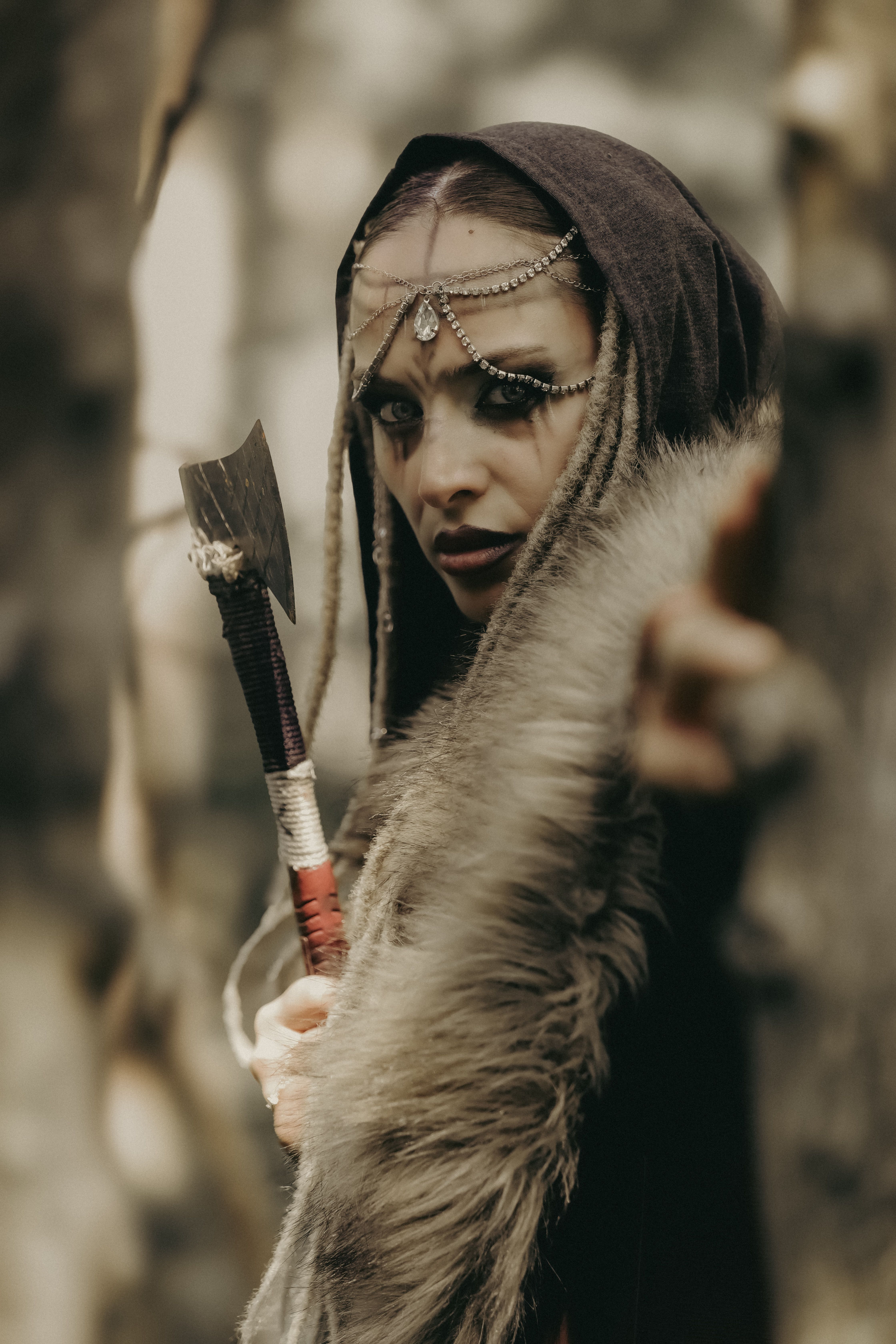 Mysterious warrior in a forest setting holding an axe, exuding a mystical vibe.