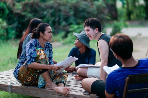 Free A diverse group enjoying a lively conversation outdoors on a sunny day. Stock Photo