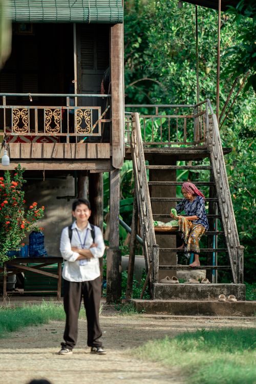 Free A scene capturing daily life near a traditional elevated wooden house in a rural setting. Stock Photo