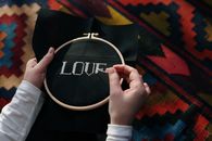 Close up of a Person Doing Embroidery Work on Black Fabric
