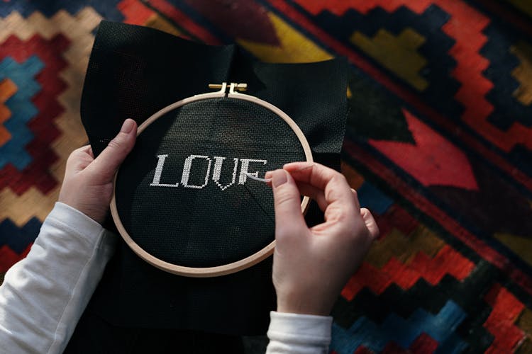 Close Up Of A Person Doing Embroidery Work On Black Fabric 