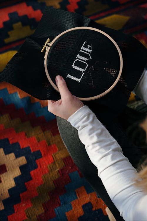 Person Doing Hand Embroidery On Black Textile