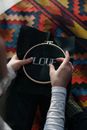 A Person Doing Embroidery Work on Black Fabric