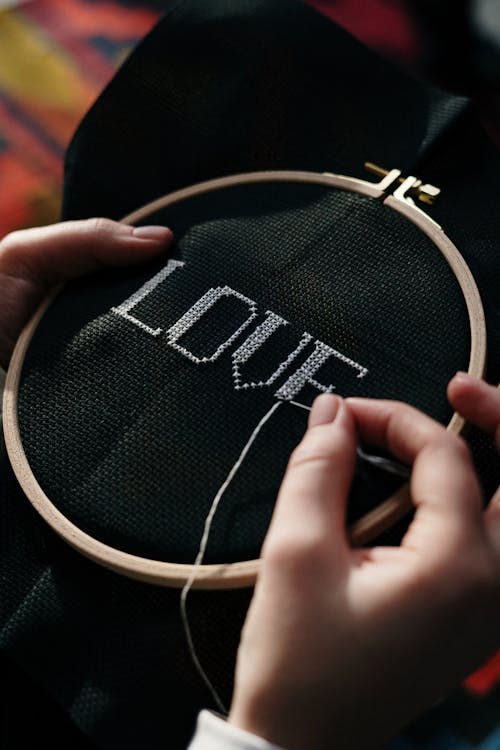 Free Person Hand Embroidering on Black Textile Stock Photo