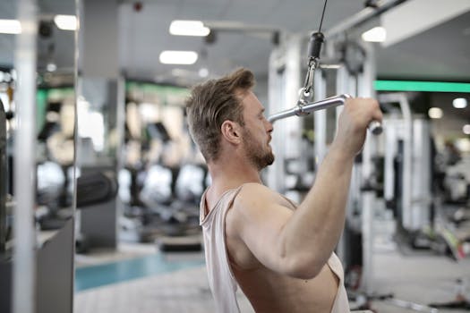 Focused man performing lat pulldown exercise indoors.
