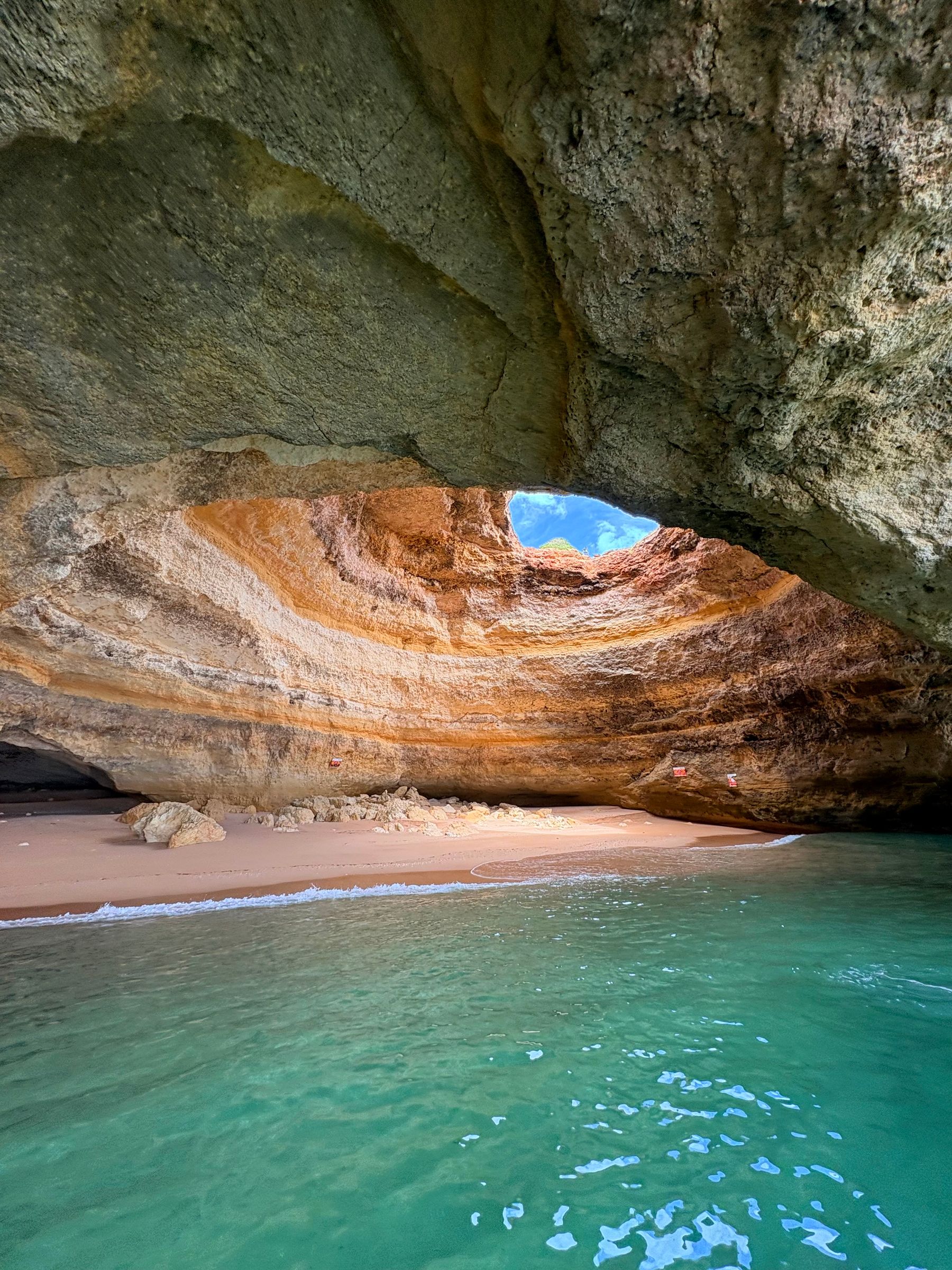 Inside the Benagil sea cave, with sunlight through the opening in its roof