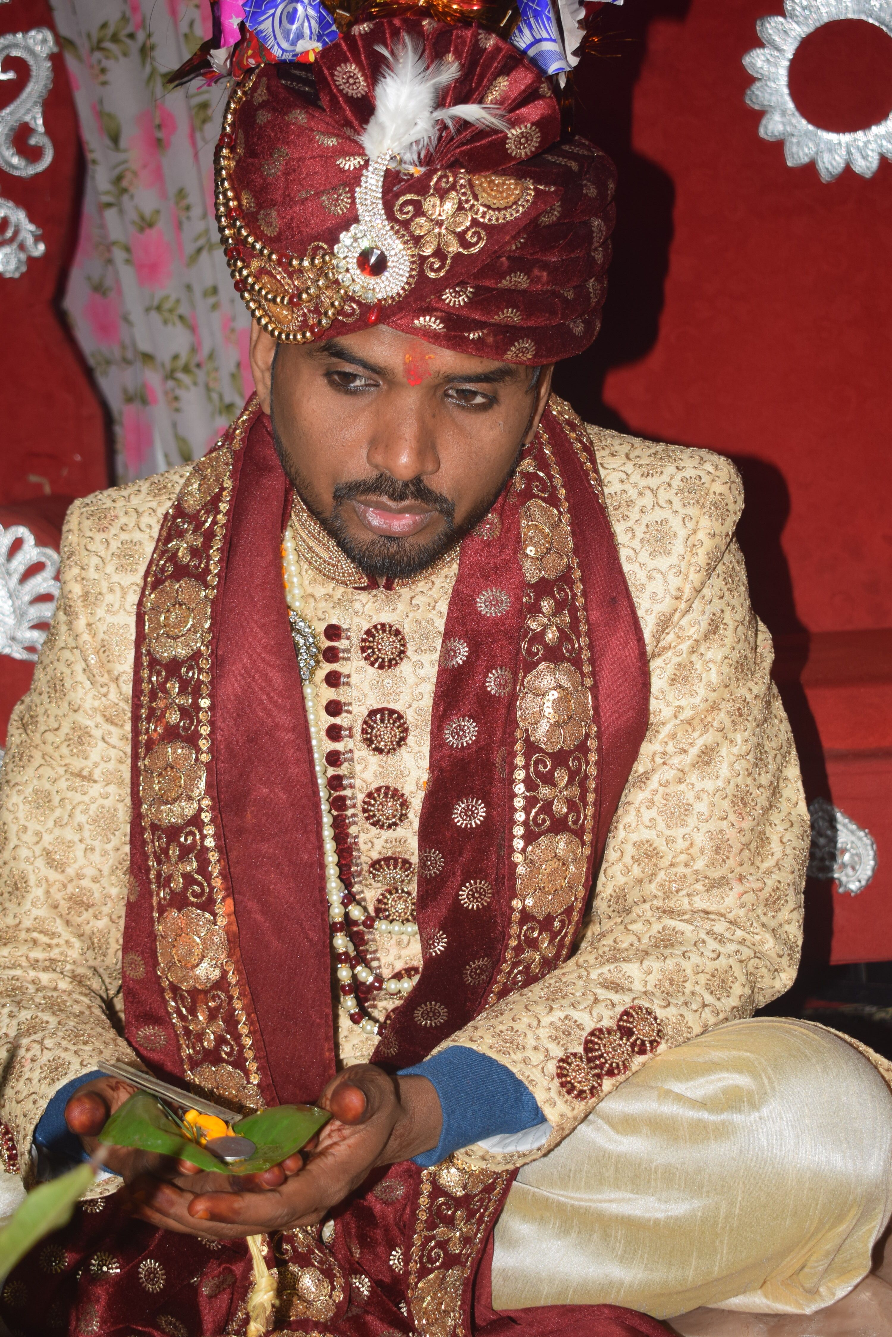 A South Asian groom in ornate traditional attire during a cultural wedding ceremony.