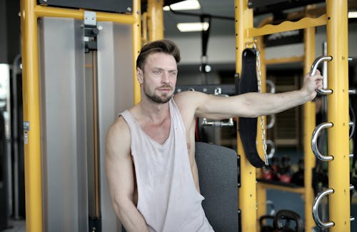 Ernstige Gespierde Mannelijke Atleet Rusten In De Buurt Van Oefeningsmachine In Moderne Sportschool