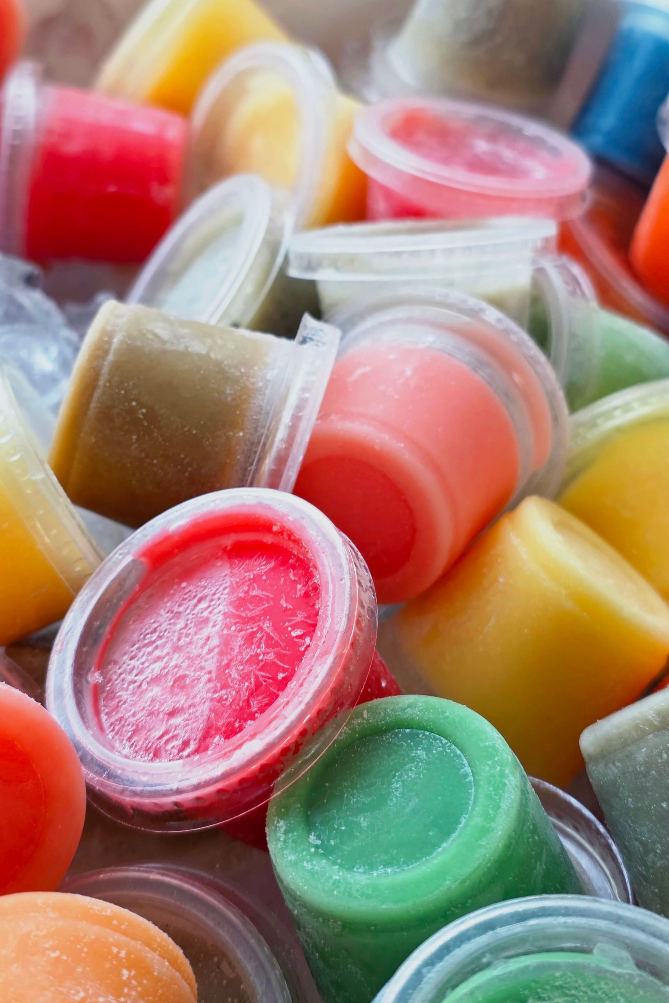 Vibrant assortment of frozen fruit sorbet cups in various flavors and colors.