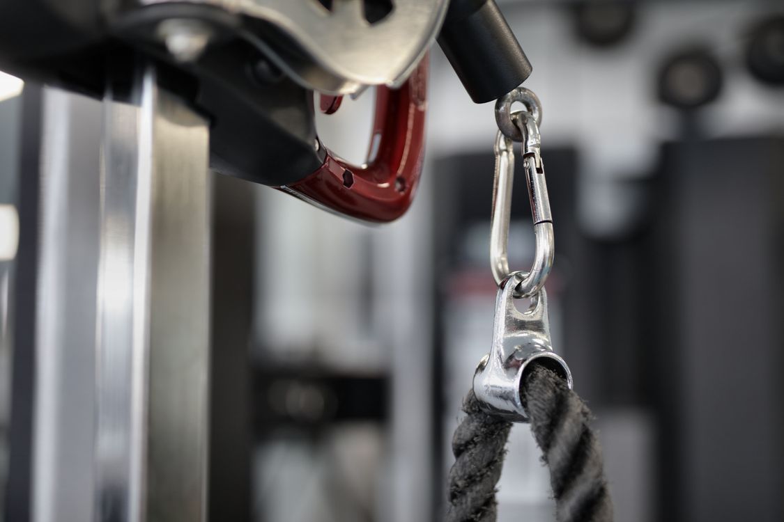 Black rope of modern exercise machine hanging on metal carabiner · Free ...