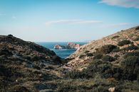 Explore the stunning coastal landscape of Agios Stefanos in Greece, featuring rugged mountains and serene sea views.