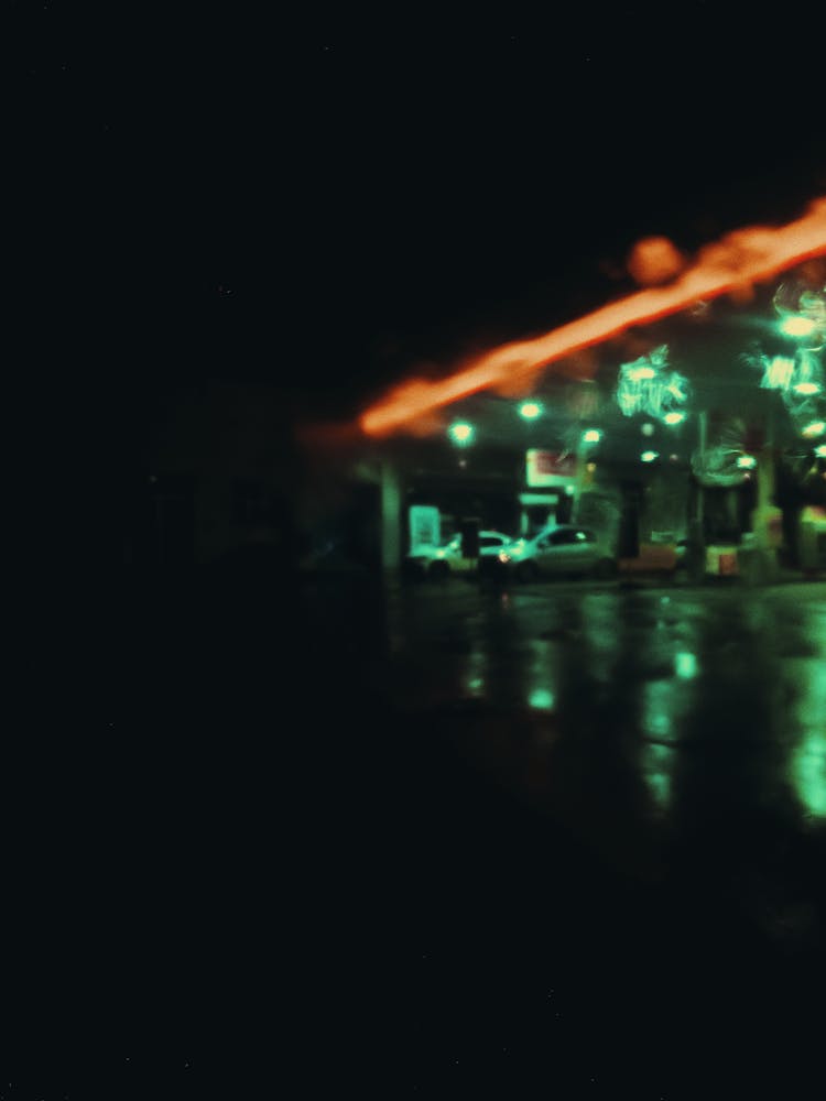 Glowing Neon Light On Street With Parked Cars At Night