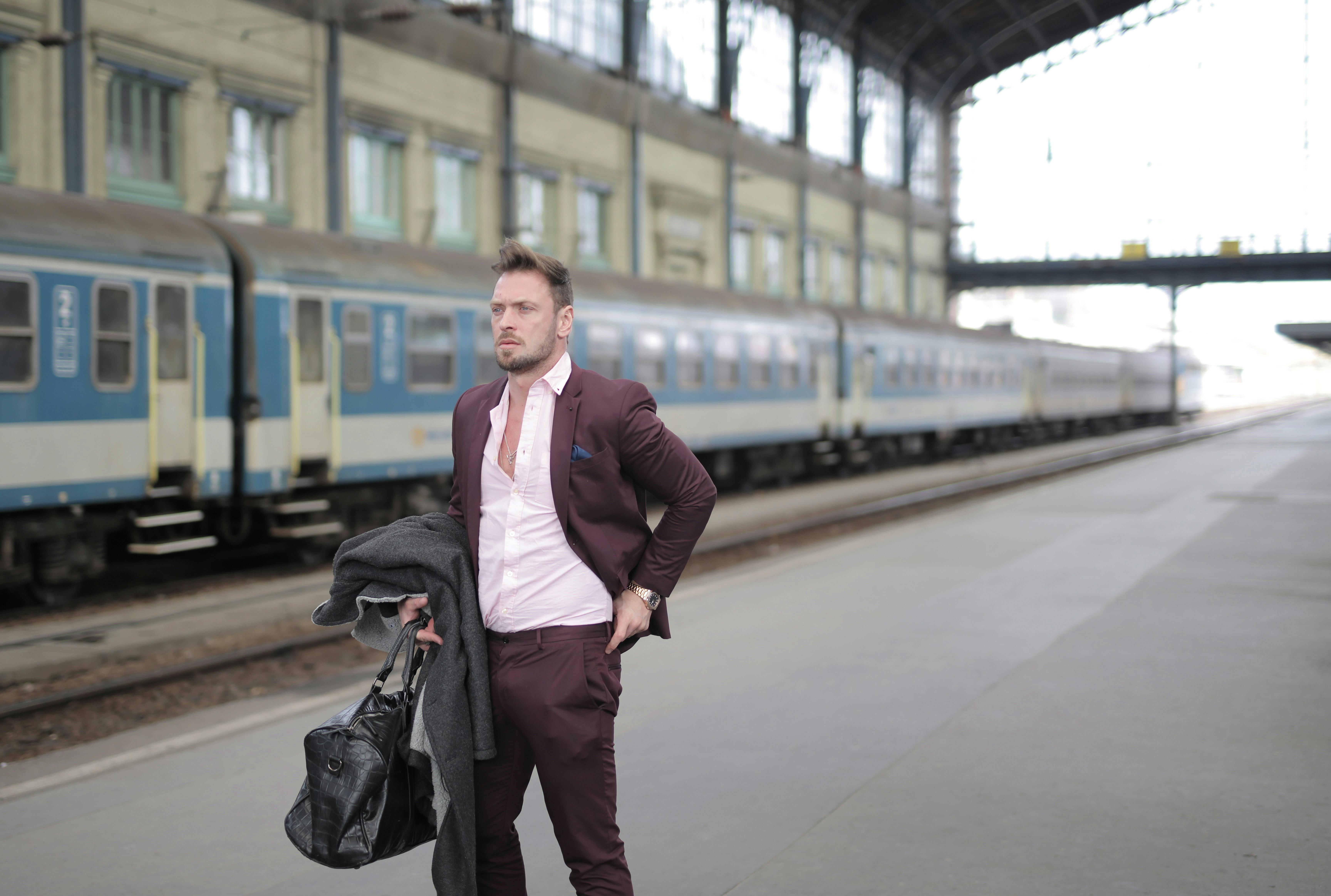 man in maroon suit standing on sidewalk