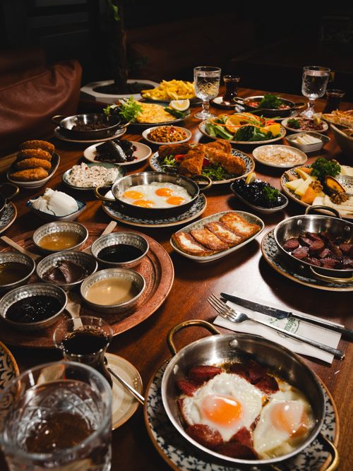 Free A rich and diverse Turkish breakfast spread featuring eggs, bread, and various sides on a wooden table. Stock Photo