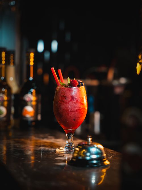 Free A refreshing berry cocktail with strawberries and blueberries served in a stylish glass at a dimly lit bar. Stock Photo