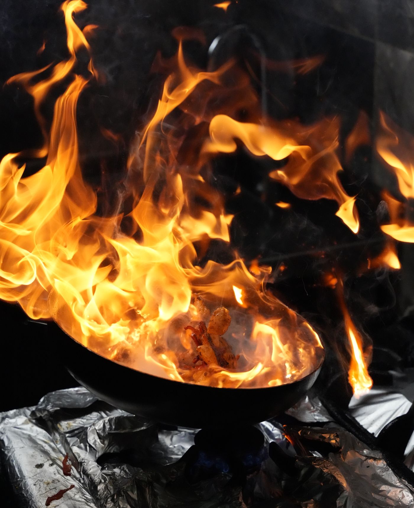 Fiery wok cooking with vibrant flames enhancing a dynamic culinary scene.