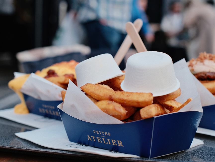 Crispy Belgian-style fries served in a paper cone at a street food stall in Brussels.