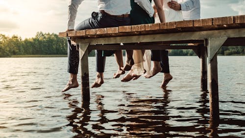 Free People Sitting on Brown Wooden Dock Stock Photo