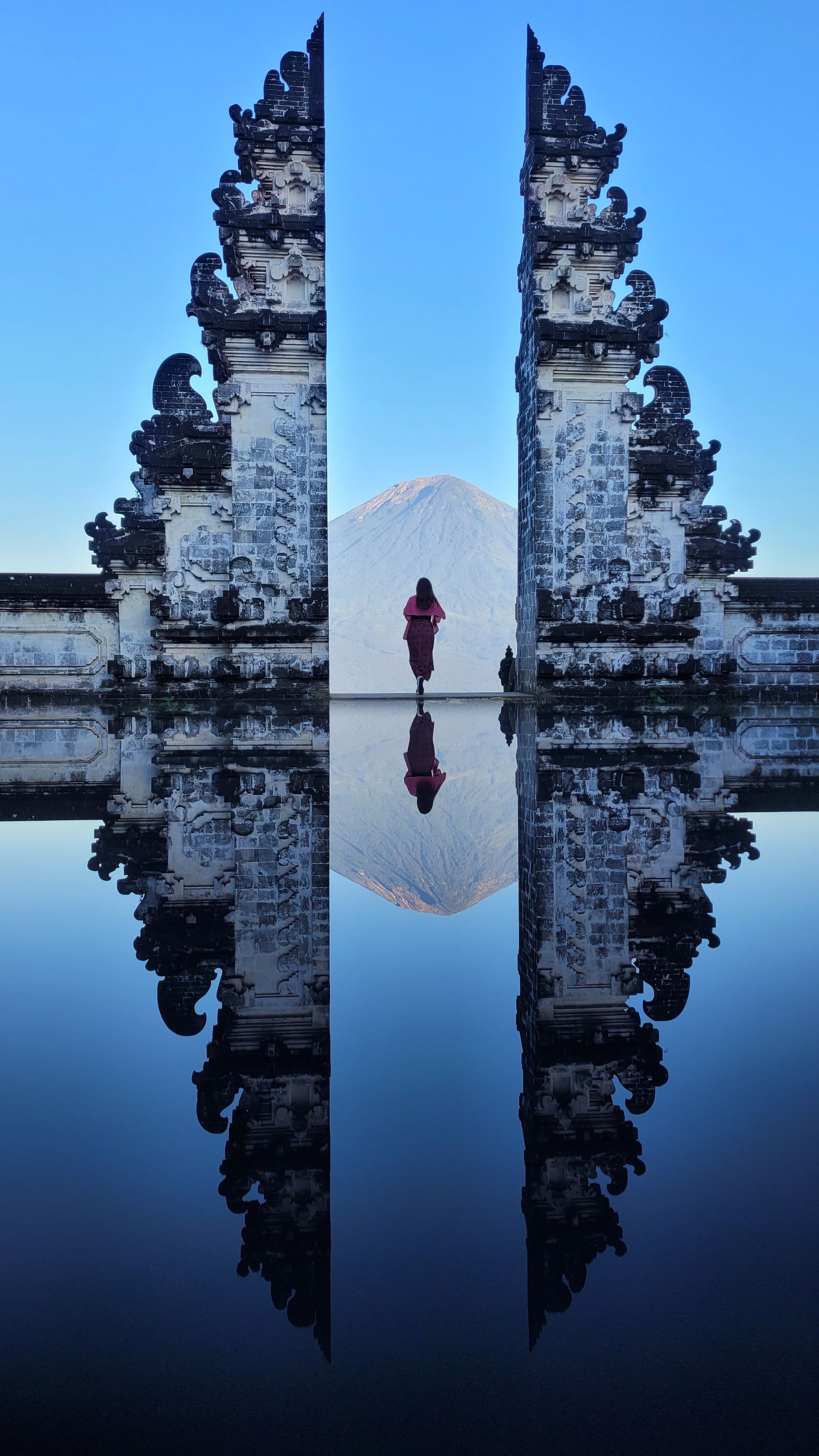 A stunning symmetrical reflection at Pura Lempuyang Temple in Bali, showcasing serene architecture and mountain views.