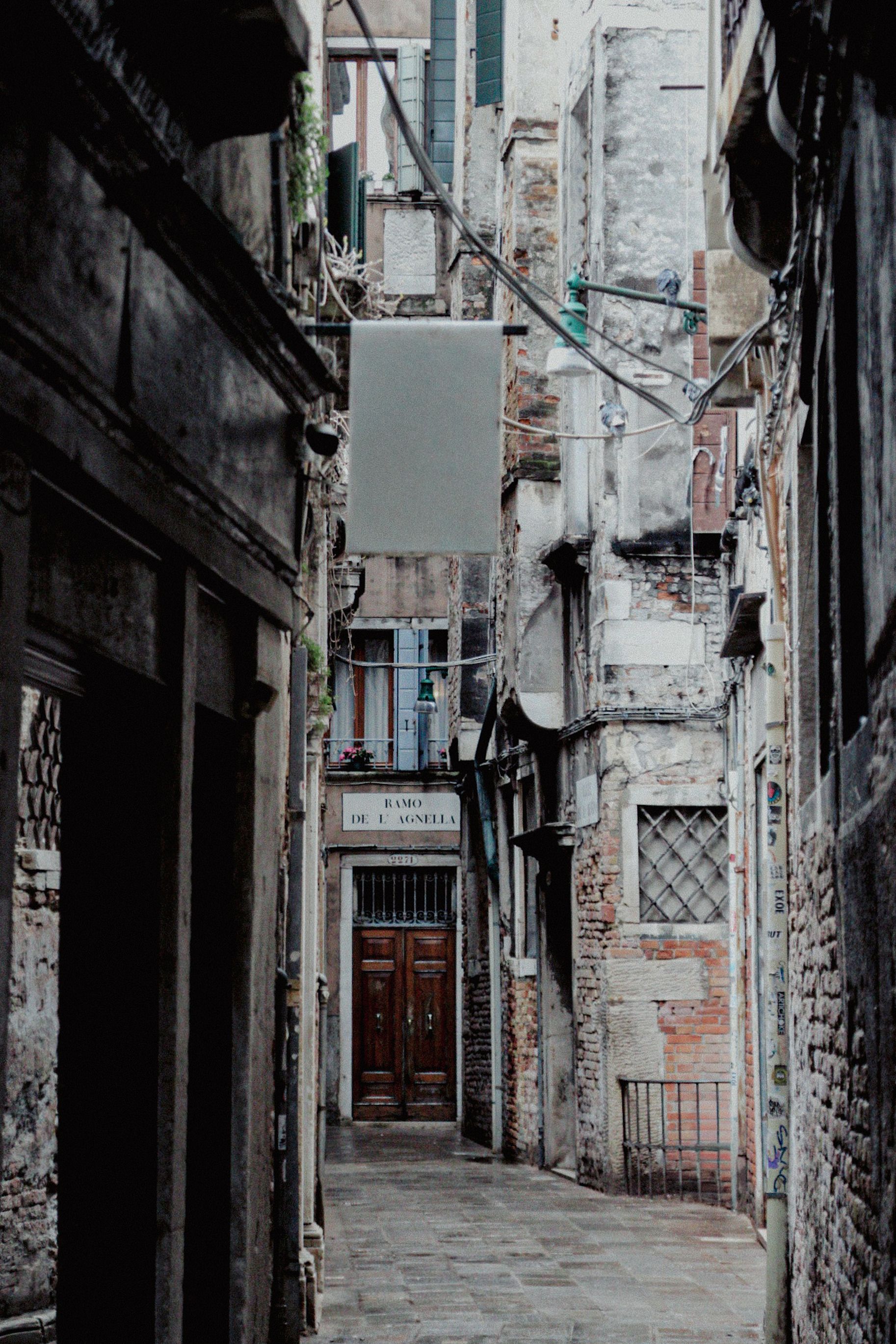 Explore the rustic charm of a narrow alleyway in Venice's historic district, Italy.