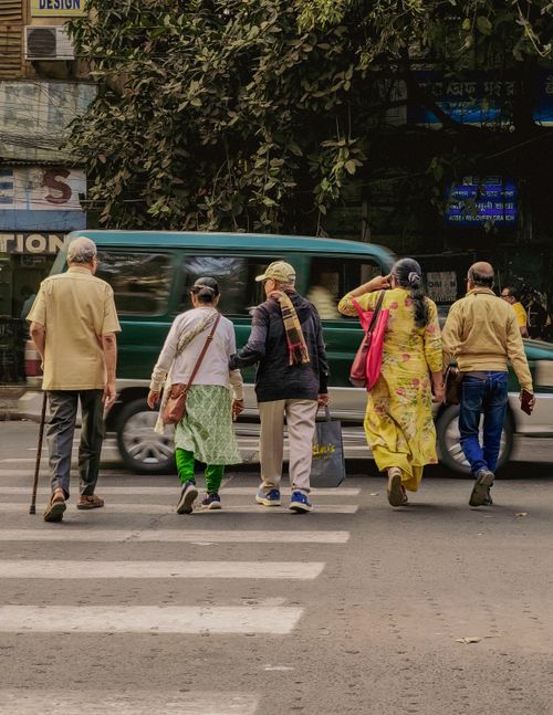 Free A group of adults crossing a city street at a crosswalk, showcasing daily urban life. Stock Photo
