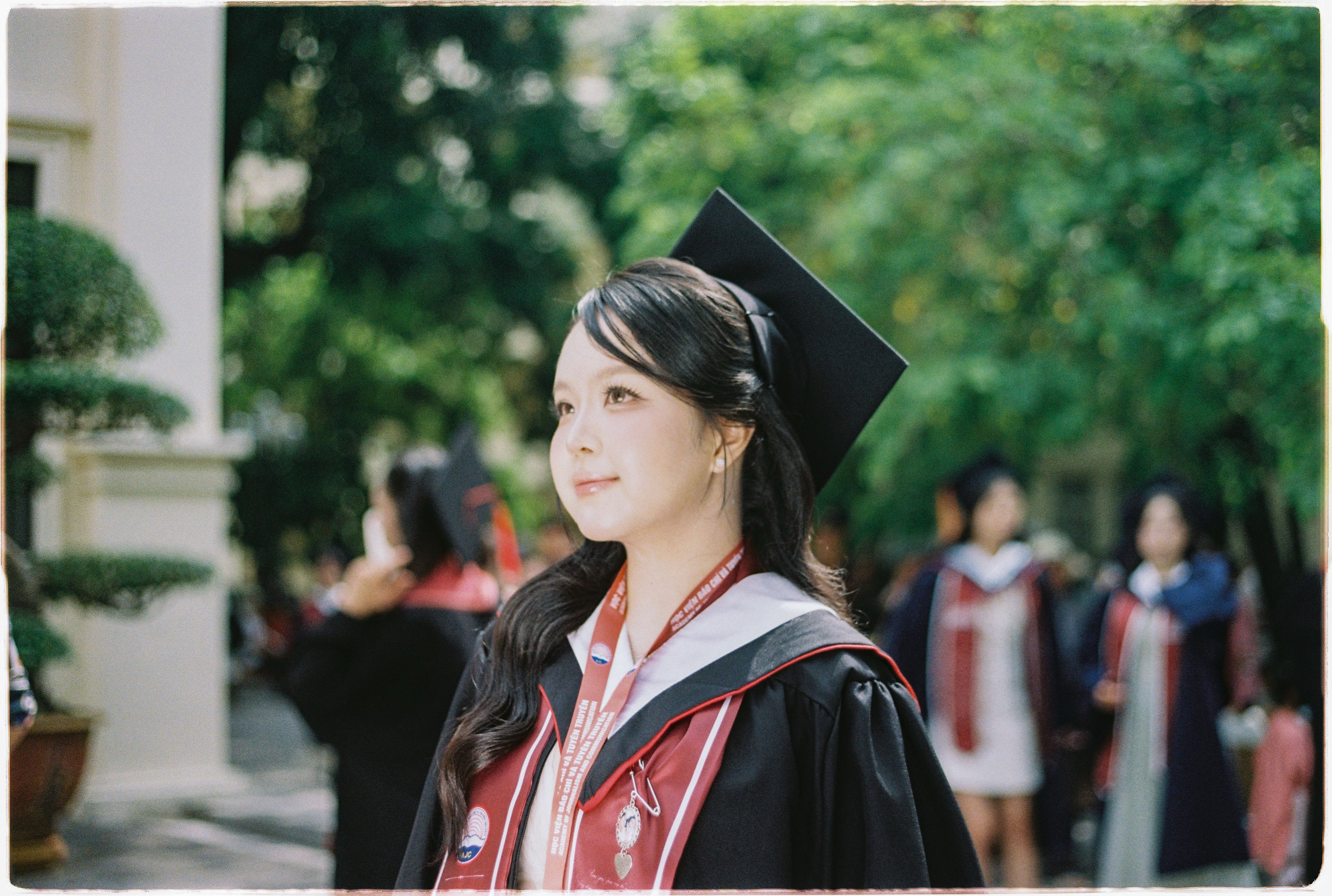 Asian Graduate in Cap and Gown Celebrating Graduation