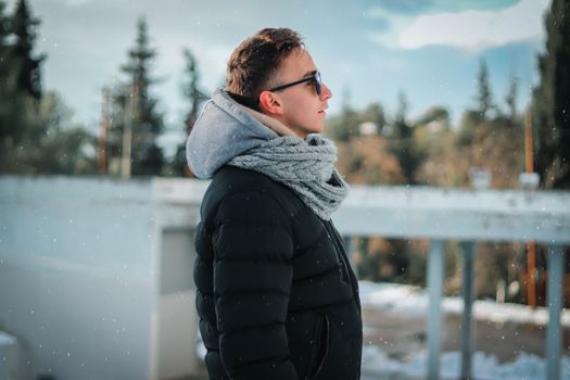 A stylish adult in warm clothing, enjoying a snowy day in Thiva, Greece.