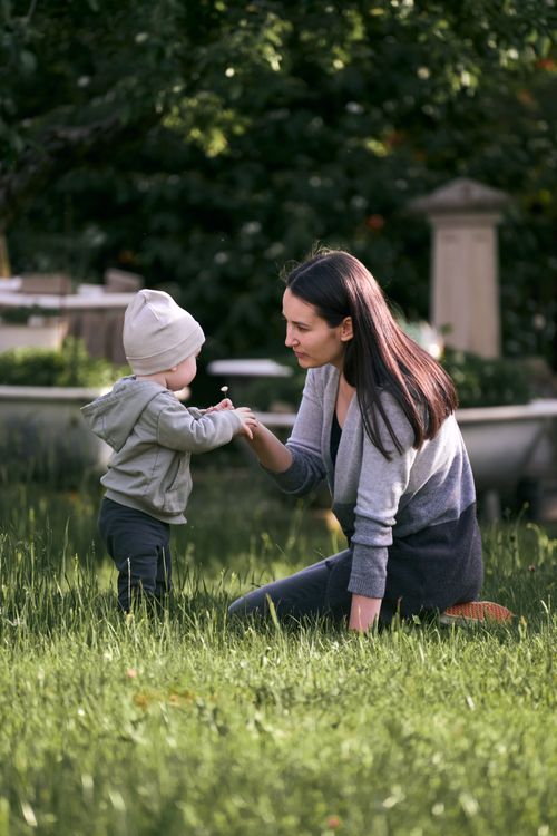 Free A mother and her toddler enjoy a sunny playtime in a lush green garden. Stock Photo