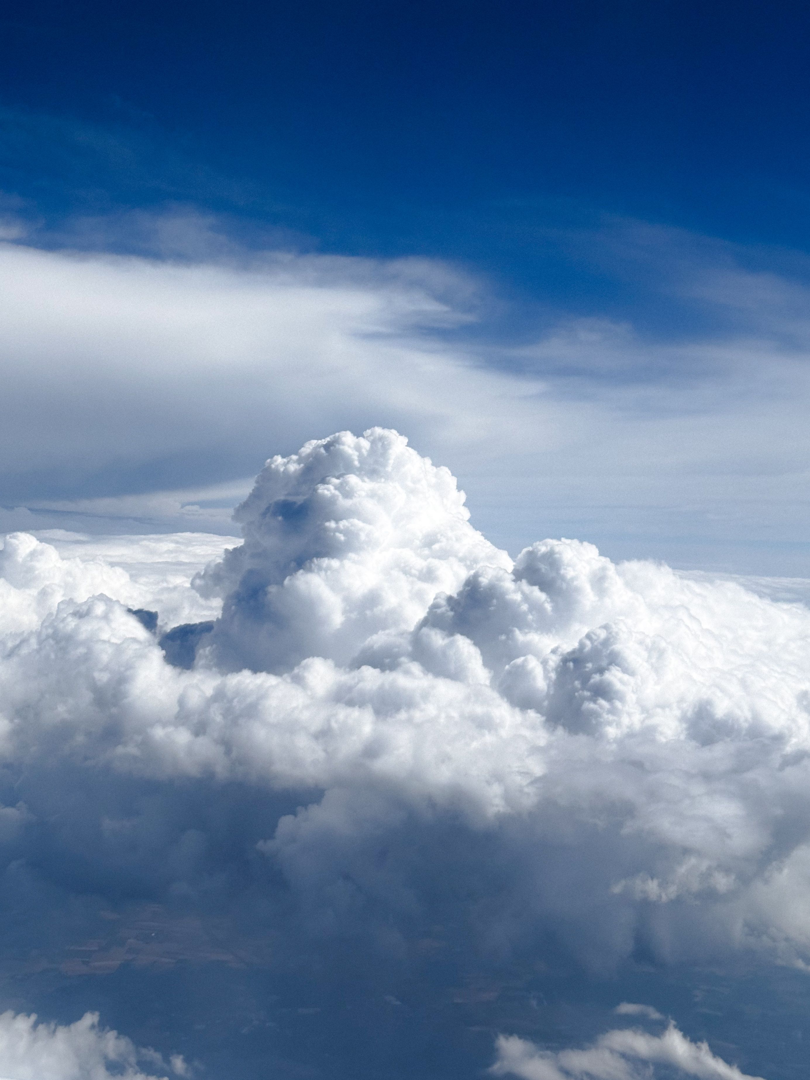 A breathtaking aerial view of a cumulus cloud formation against a deep blue sky, showcasing nature's beauty.
