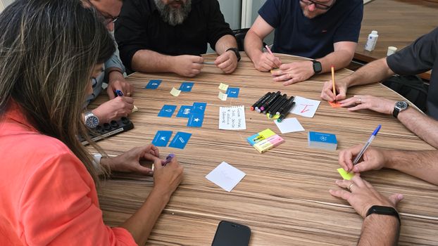 Diverse team engaged in a brainstorming session with cards and sticky notes on a round table.