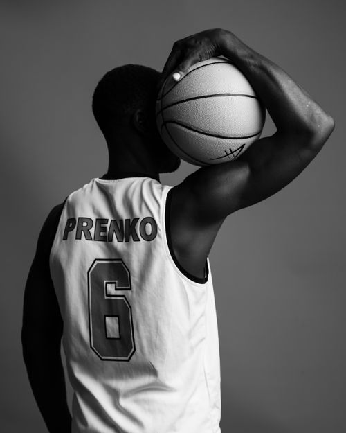 Free Black and white photo of a basketball player holding the ball over their shoulder. Stock Photo