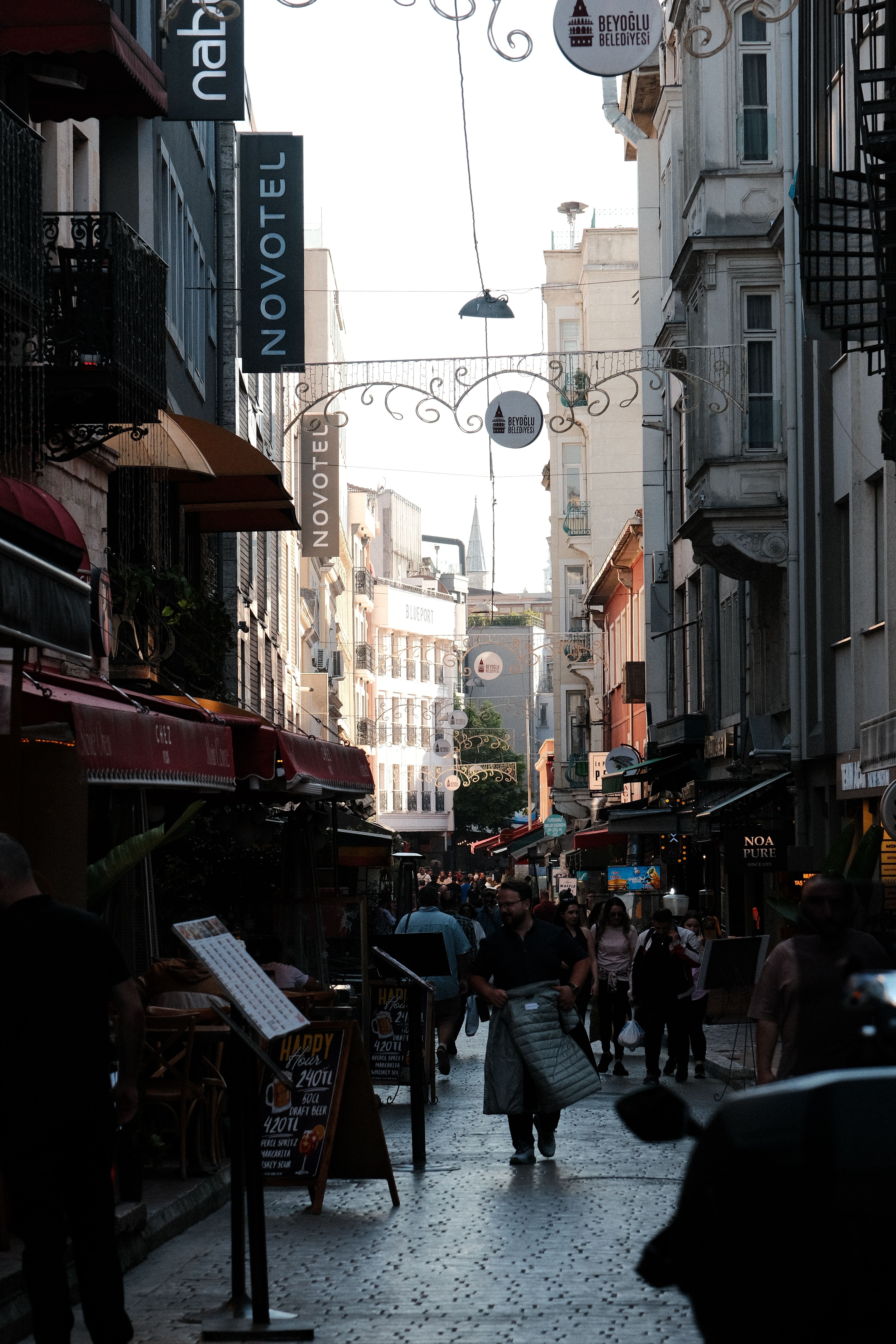 A lively European street scene featuring historic architecture and busy pedestrians.