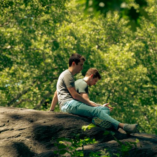 Two friends sitting and talking on a rock in the park — photo by _ Whittington on Pexels