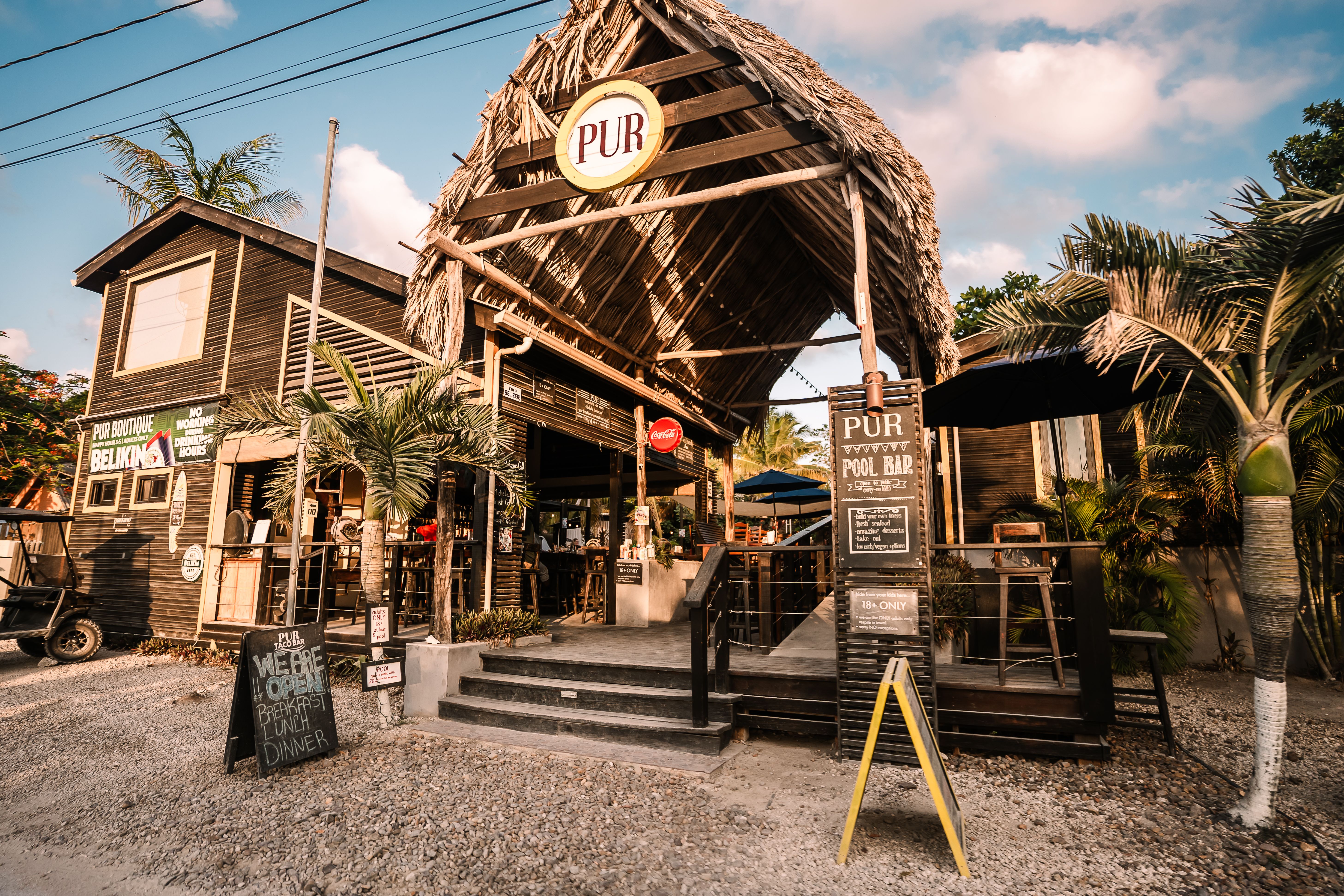 Charming outdoor bar with thatched roof in a tropical setting, perfect for relaxation.