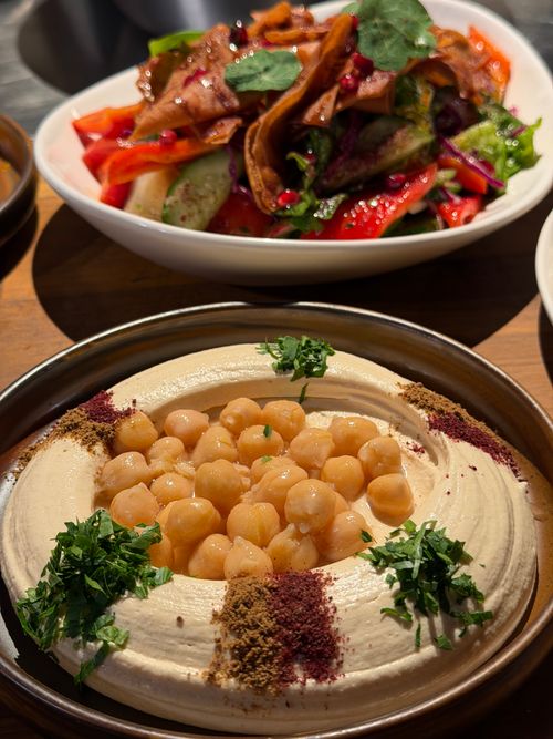 Free A delicious display of creamy hummus with chickpeas and a fresh Fattoush salad. Stock Photo