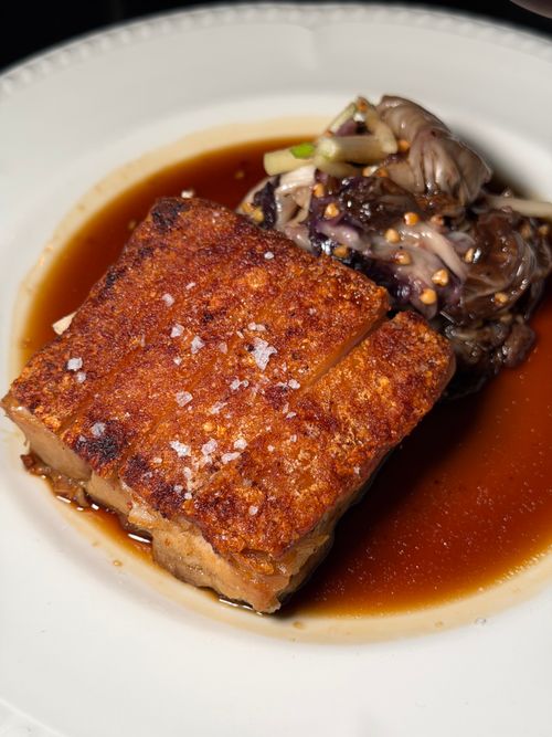 Free Delicious crispy pork belly served with a savory mushroom sauce, perfect for gourmet dining. Stock Photo