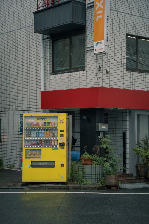 Free Vibrant yellow vending machine at a street corner in Tokyo, Japan. Stock Photo
