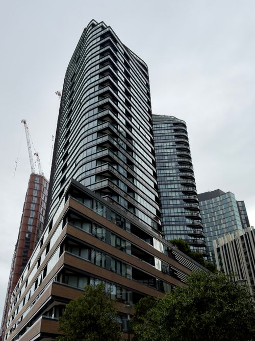 Free Contemporary buildings and cranes under cloudy sky in Docklands, Victoria. Stock Photo