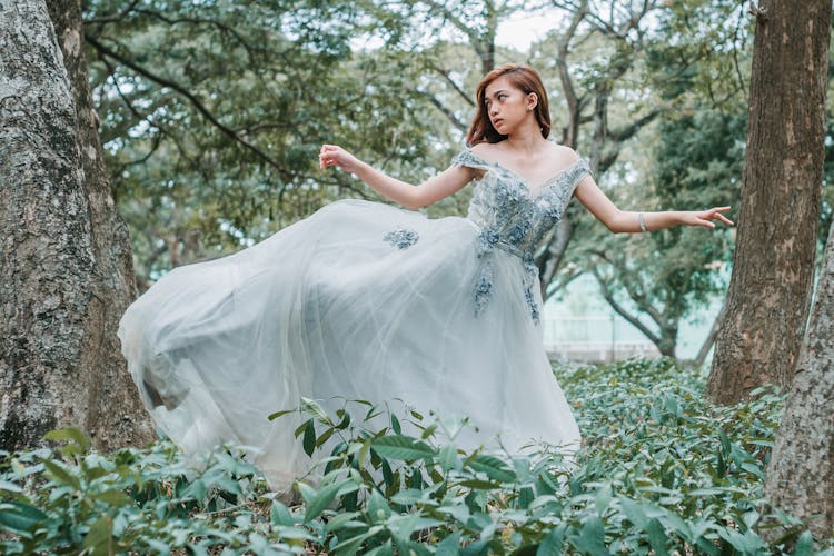 Romantic Ethnic Woman In Ball Dress Dancing In Garden