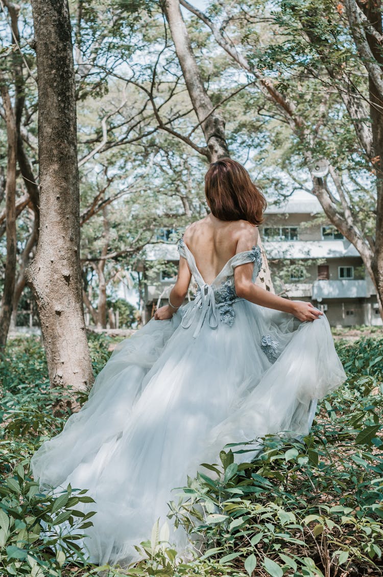 Anonymous Elegant Bride Walking In Green Garden