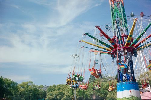 Free Vibrant amusement park carousel ride with people enjoying a sunny day. Stock Photo