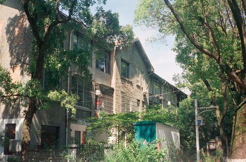 Free Historic building with brick facade in a lush urban setting on a sunny day. Stock Photo