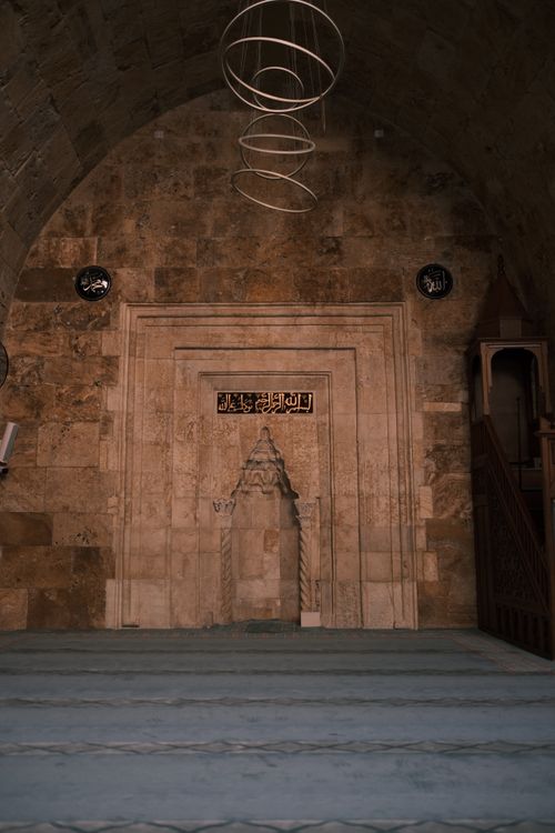 Free Elegant stone archway inside a historical mosque, featuring decorative carvings and calligraphy. Stock Photo