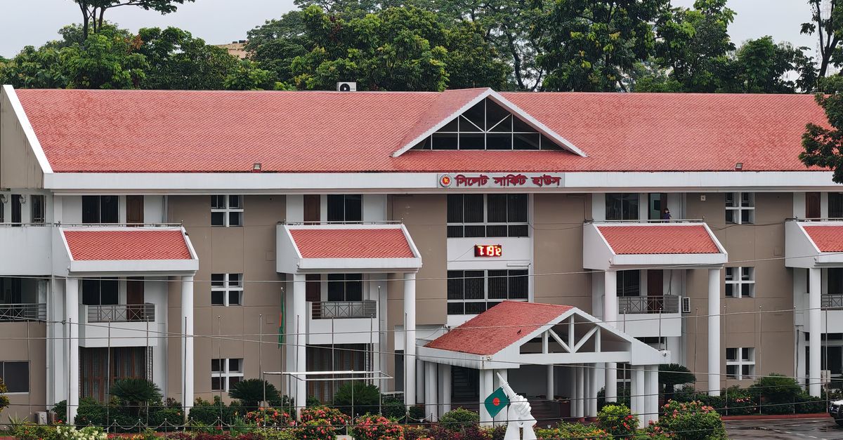 Front view of Sylhet Circuit House with neatly maintained garden and red roof.