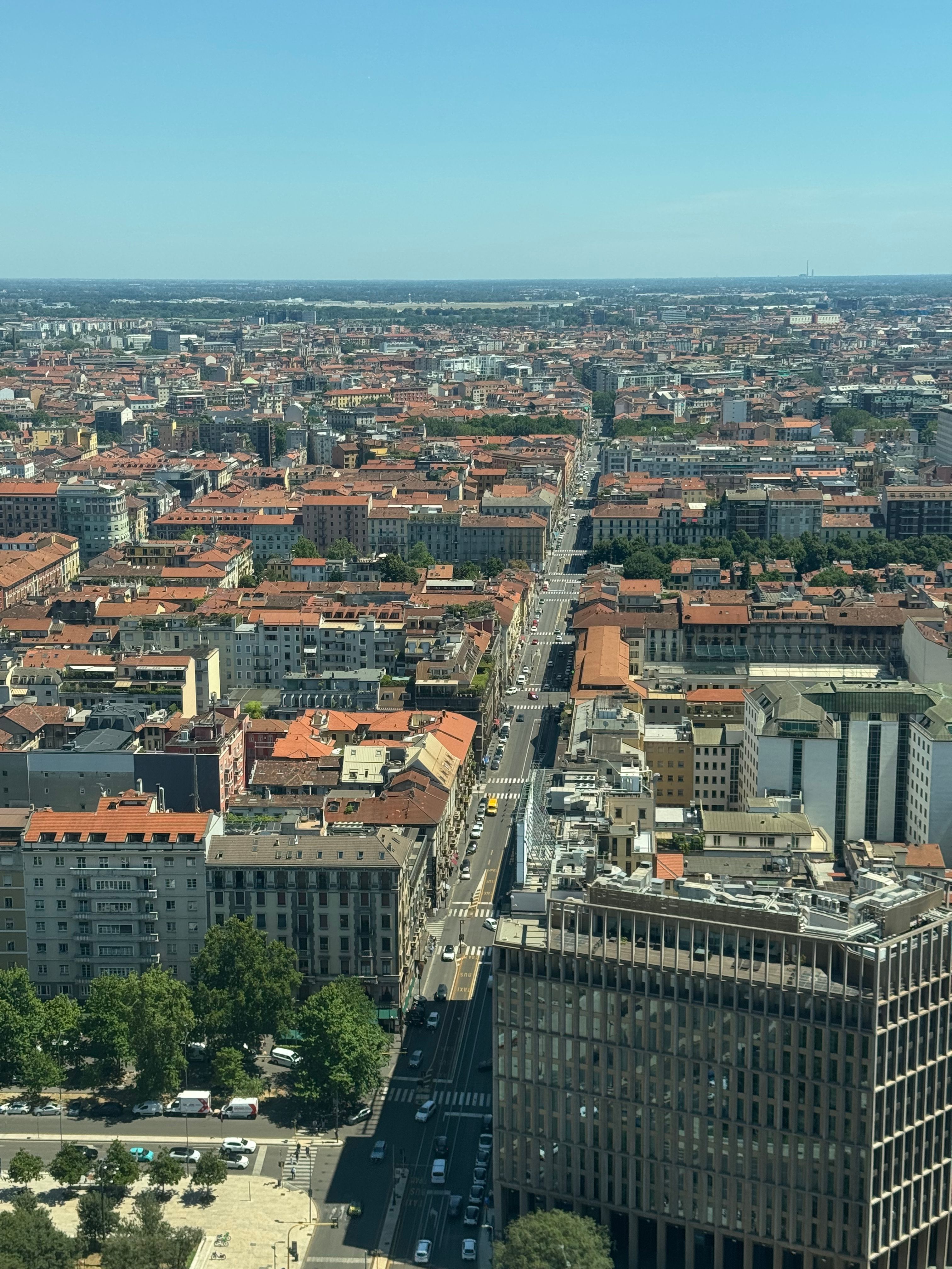 Panoramic aerial view of Milano, Italy showcasing urban architecture and summer scenery.