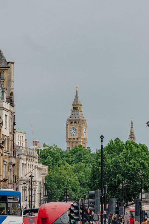 Free Classic view of Big Ben amidst the vibrant streets of London on a cloudy day. Stock Photo