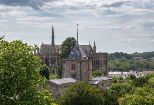 Free A stunning capture of a historic cathedral surrounded by lush greenery on a bright day. Stock Photo