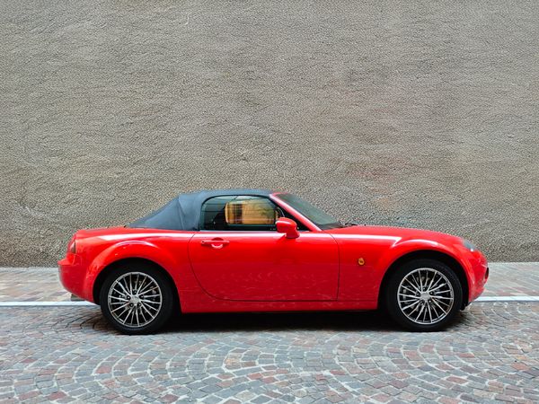 Red convertible parked beside a textured wall — photo by miata7 MX-5 on Pexels